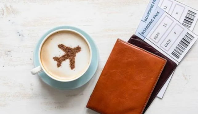 Airport flight tickets next to a coffee mug